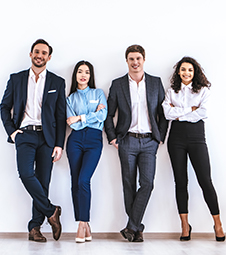 4 employees standing against a white wall